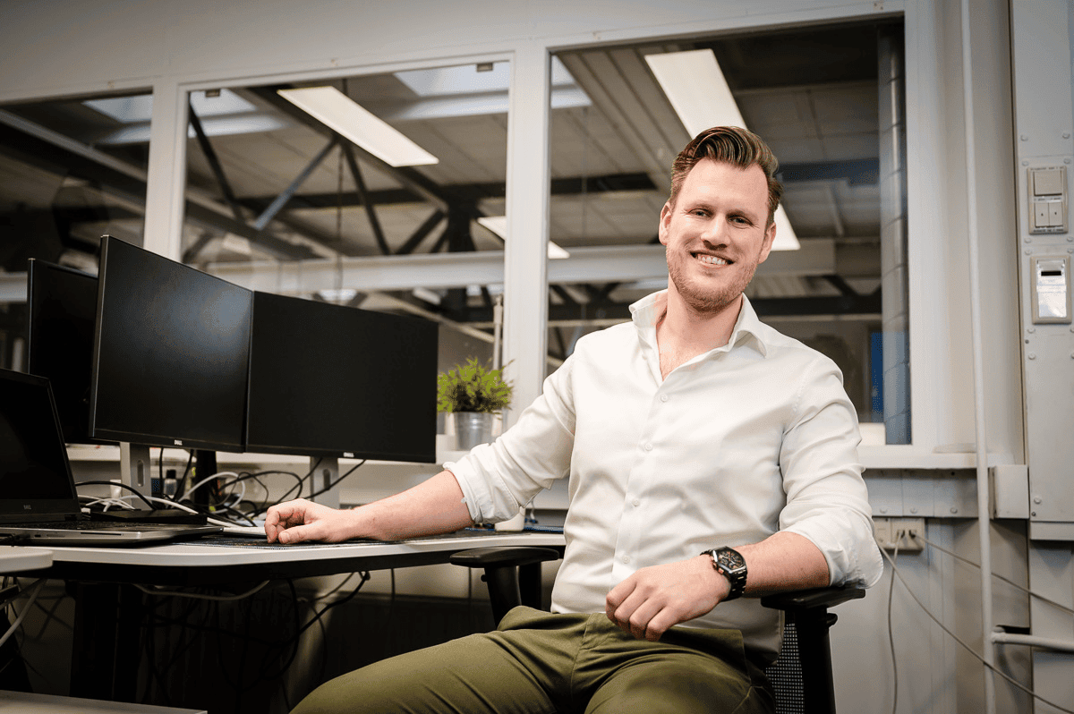 Persoon achter computer Persoon zit achter een bureau en werkt op een computer in kantooromgeving