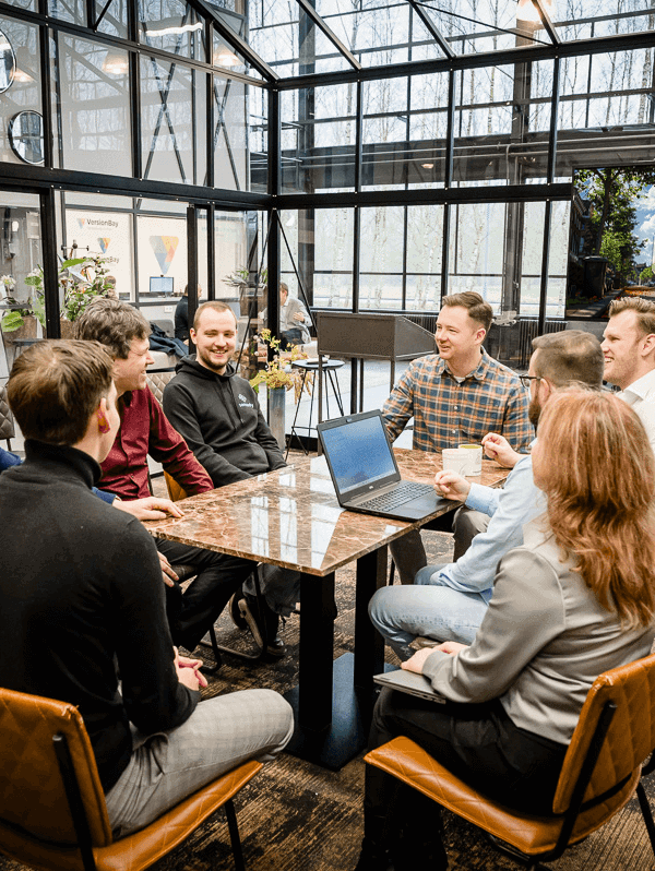 Binfinity team members sitting at a table having a meeting in an office space