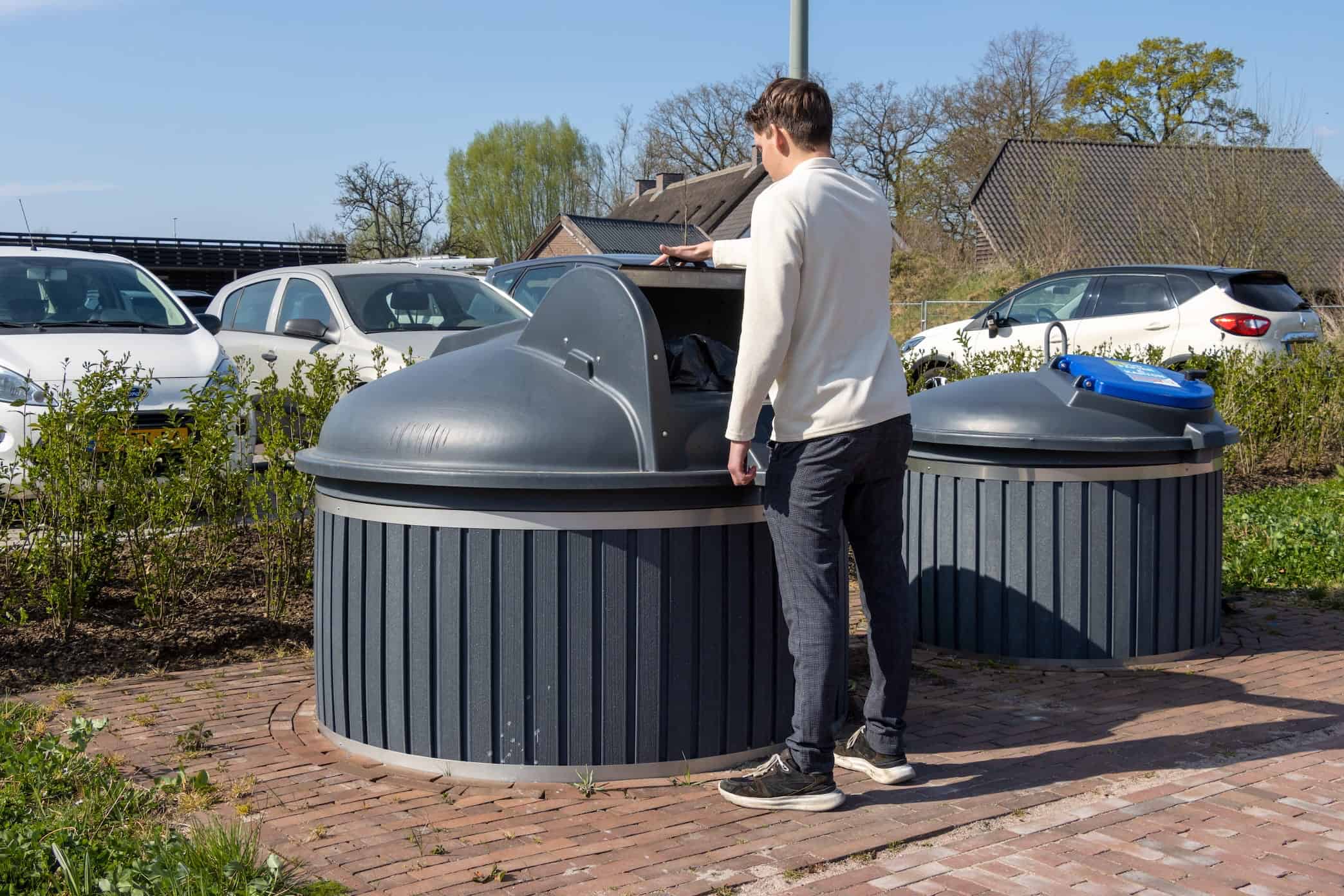 Buurtbewoner gooit iets in een ondergrondse container - Binfinity Access Buurtbewoner gooit iets in een ondergrondse container - Binfinity Access